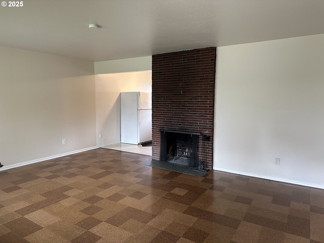 unfurnished living room with dark carpet and a fireplace