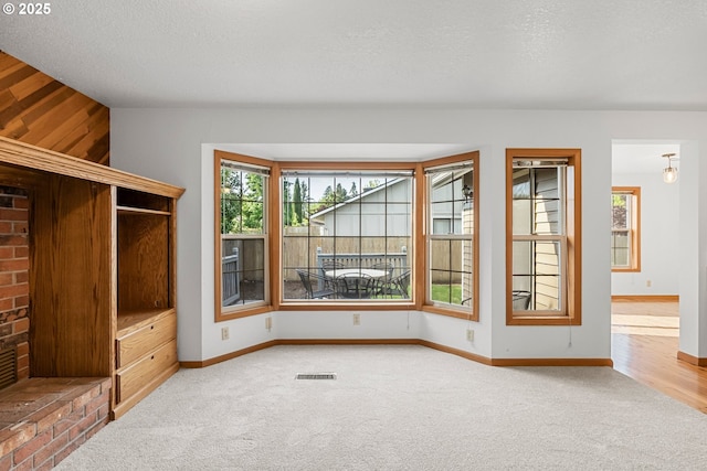 interior space with plenty of natural light, baseboards, and a textured ceiling