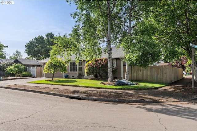 view of property hidden behind natural elements featuring crawl space, fence, concrete driveway, and a shingled roof