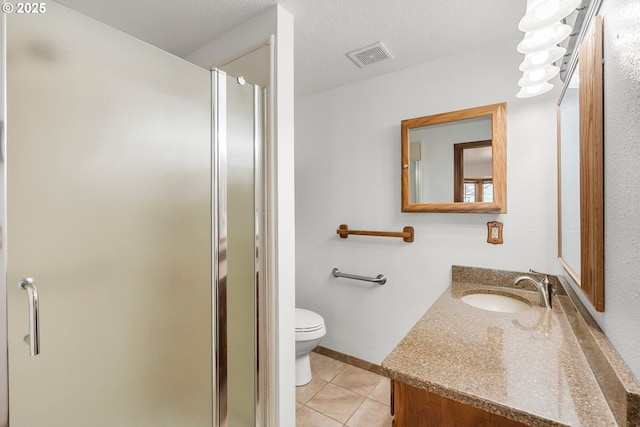 bathroom with tile patterned flooring, toilet, a shower stall, and vanity