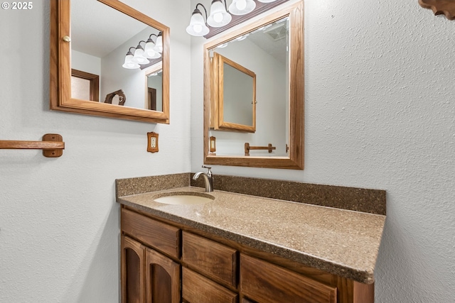 bathroom featuring vanity and a textured wall