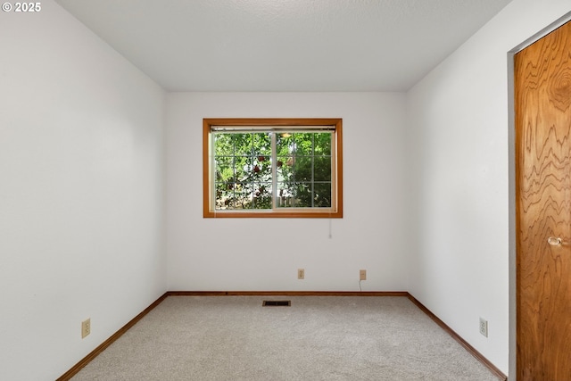 carpeted empty room featuring baseboards