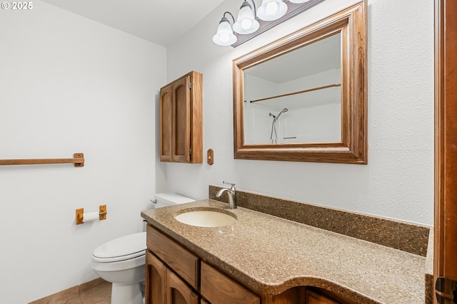 bathroom featuring toilet, vanity, tile patterned floors, and a shower