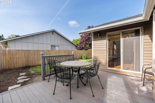 deck with outdoor dining area and a fenced backyard