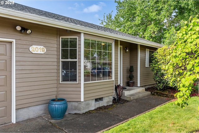 doorway to property featuring a shingled roof