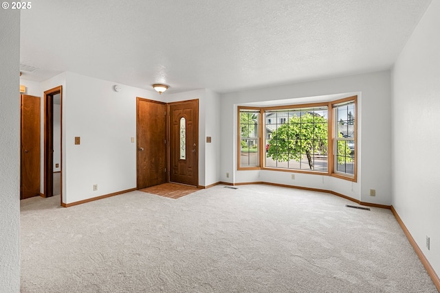 carpeted entryway with baseboards and a textured ceiling