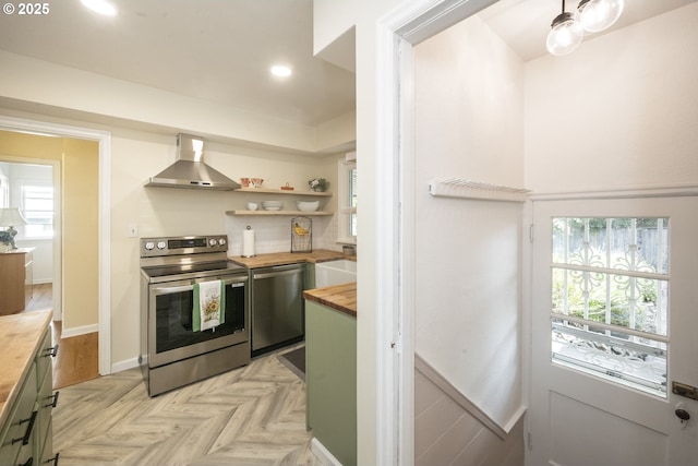 2535 N Baldwin St, Portland, OR 97217 - kitchen with wood counters, stainless steel appliances, wall chimney exhaust hood, recessed lighting, and healthy amount of natural light