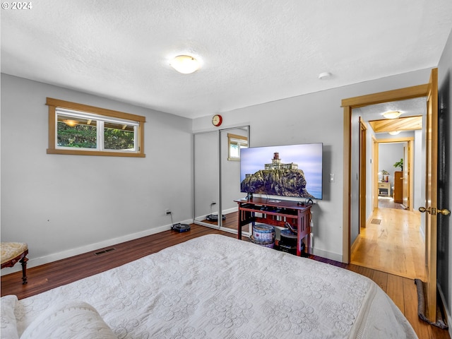 89610 Sea Breeze Dr, Warrenton, OR 97146 - bedroom with a textured ceiling, visible vents, wood finished floors, and baseboards