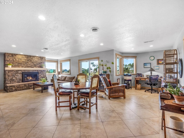 89610 Sea Breeze Dr, Warrenton, OR 97146 - dining area with a fireplace, a textured ceiling, visible vents, and recessed lighting
