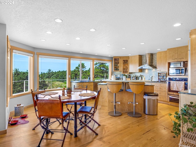 89610 Sea Breeze Dr, Warrenton, OR 97146 - dining room with light wood finished floors, a textured ceiling, baseboards, and recessed lighting