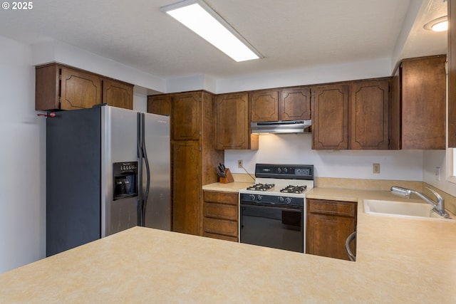 kitchen with stainless steel refrigerator with ice dispenser, under cabinet range hood, a sink, gas range oven, and light countertops