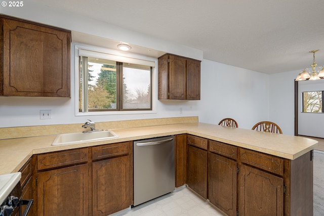 kitchen featuring light floors, a peninsula, a sink, light countertops, and dishwasher