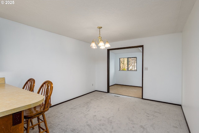 dining room featuring carpet flooring, baseboards, visible vents, and a chandelier