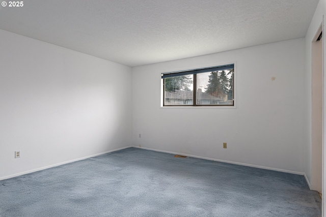 unfurnished room featuring baseboards, carpet floors, and a textured ceiling