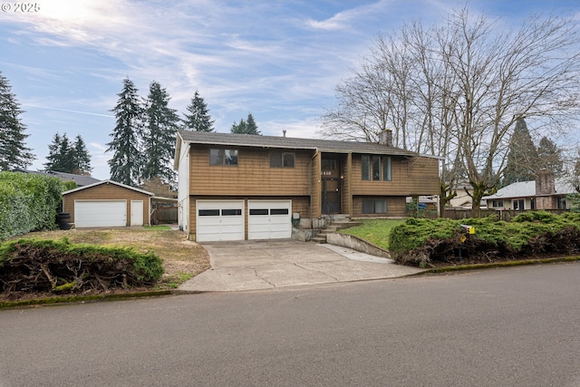 split foyer home featuring a chimney, an attached garage, and concrete driveway