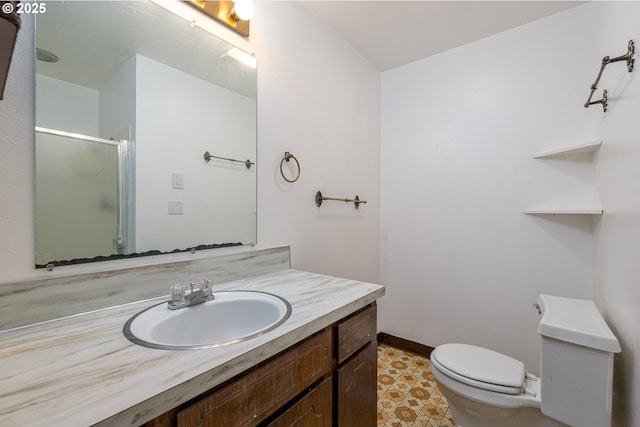 full bathroom featuring toilet, vanity, baseboards, and a shower with shower door