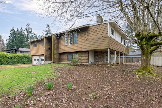 view of front of house with fence, a garage, and a chimney