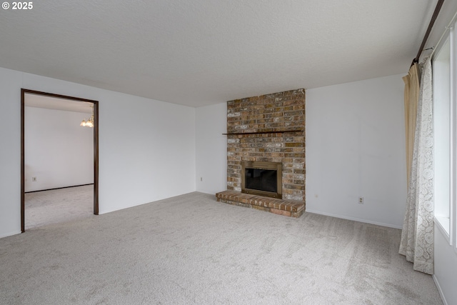 unfurnished living room featuring carpet flooring, a fireplace, and a textured ceiling