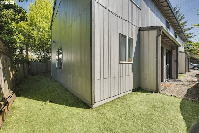 view of property exterior with fence and a yard