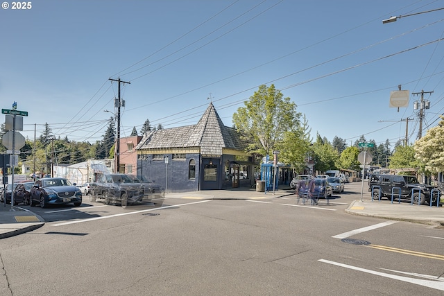 view of road with street lighting, traffic signs, sidewalks, and curbs