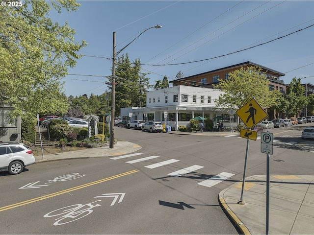 view of street featuring sidewalks, traffic signs, curbs, and street lights
