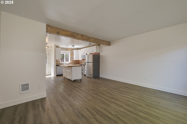 unfurnished living room with baseboards, beam ceiling, visible vents, and dark wood-style floors