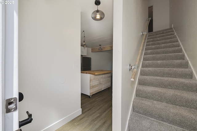 stairway with baseboards and wood finished floors