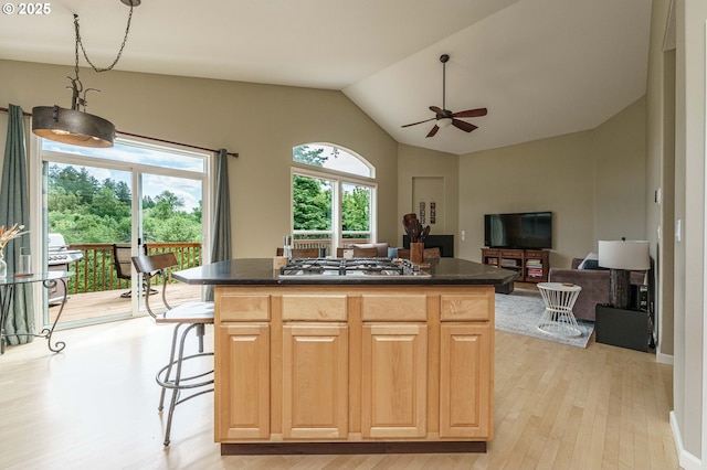 1216 SE 47th St, Hillsboro, OR 97123 - kitchen featuring stainless steel gas stovetop, ceiling fan, dark countertops, light wood-style flooring, and a kitchen island