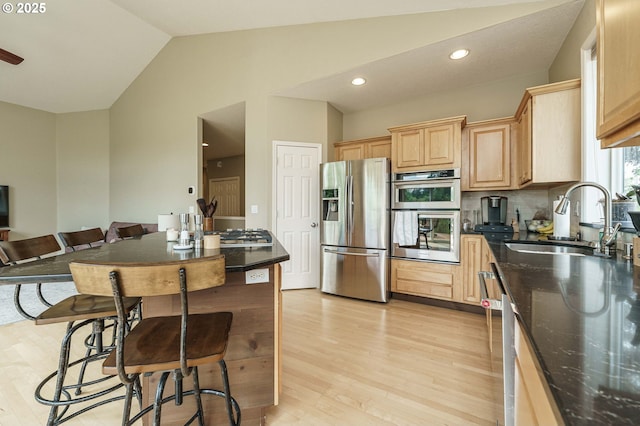 1216 SE 47th St, Hillsboro, OR 97123 - kitchen featuring appliances with stainless steel finishes, a sink, vaulted ceiling, light brown cabinets, and light wood-style floors