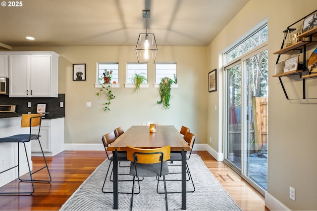 dining room featuring light wood-type flooring, baseboards, and recessed lighting