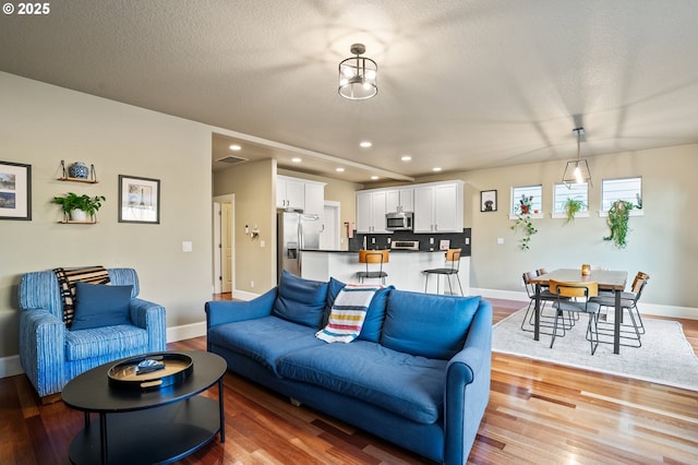 living room with light wood-style flooring, recessed lighting, and baseboards