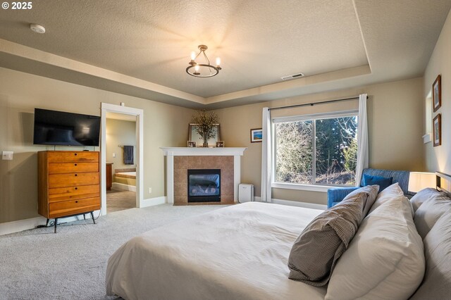 bedroom with carpet flooring, a chandelier, a tray ceiling, a fireplace, and baseboards