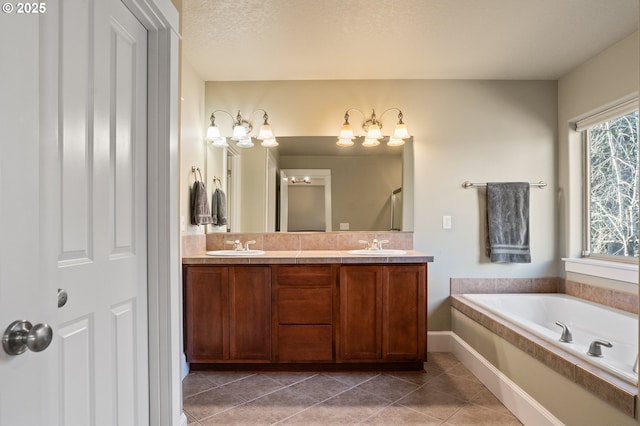 bathroom featuring double vanity, tile patterned flooring, a bath, and baseboards
