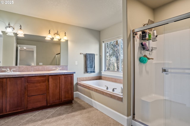 bathroom featuring a stall shower, tile patterned flooring, a garden tub, double vanity, and baseboards