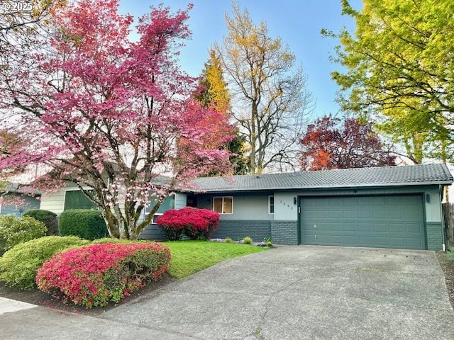 2595 Elysium Ave, Eugene, OR 97401 - view of front facade featuring brick siding, a garage, concrete driveway, and a front yard