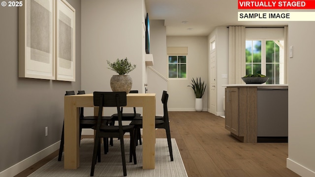 dining space featuring baseboards and wood-type flooring