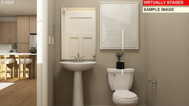 half bath with toilet and wood-type flooring