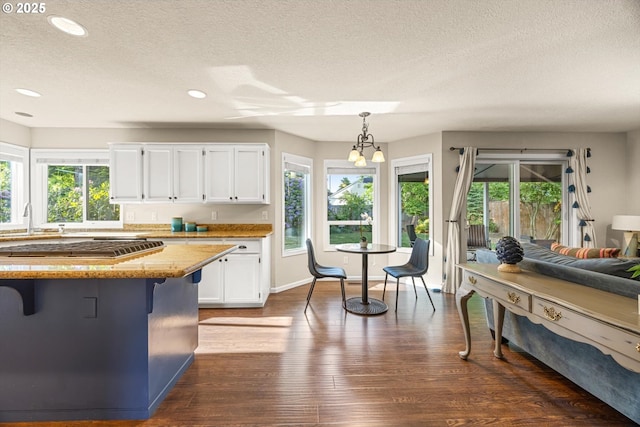 8967 SW Leslie St, Portland, OR 97223 - kitchen featuring a textured ceiling, white cabinets, a breakfast bar area, plenty of natural light, and recessed lighting