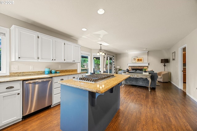 8967 SW Leslie St, Portland, OR 97223 - kitchen featuring appliances with stainless steel finishes, dark wood-type flooring, white cabinets, a center island, and recessed lighting