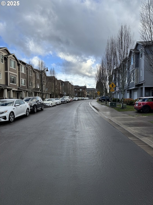 view of street with sidewalks, traffic signs, and a residential view