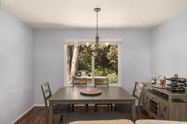 dining room with baseboards, dark wood finished floors, and a chandelier