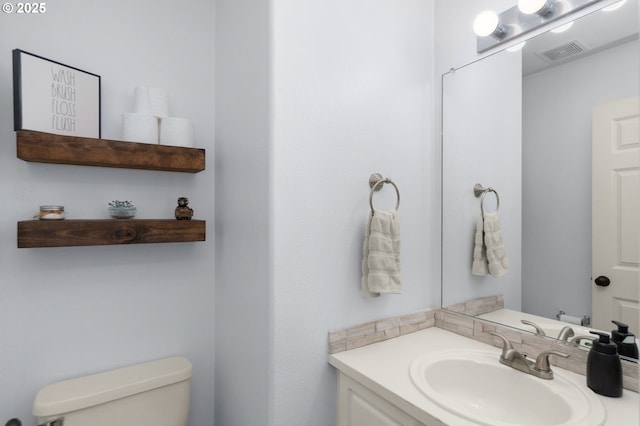 bathroom with visible vents, toilet, and vanity