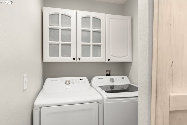 washroom featuring cabinet space and separate washer and dryer