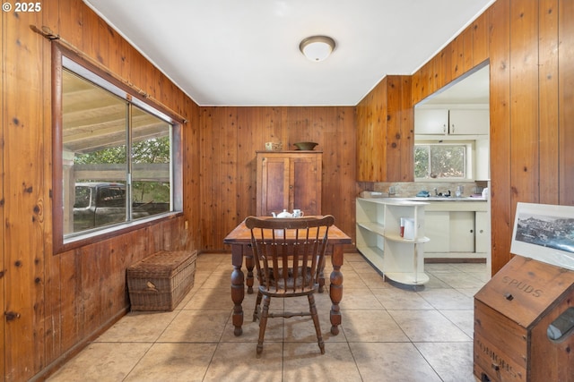 dining room with tile patterned flooring and wooden walls