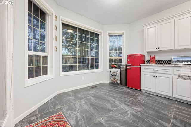 kitchen featuring light stone countertops and white cabinetry