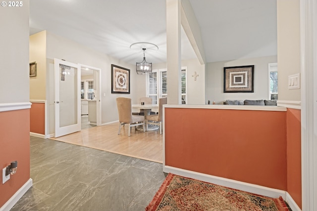 interior space featuring french doors, decorative light fixtures, and a notable chandelier