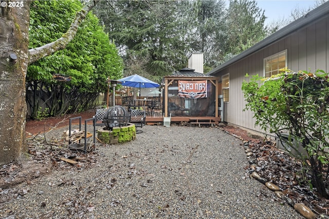 view of yard featuring a deck and an outdoor fire pit