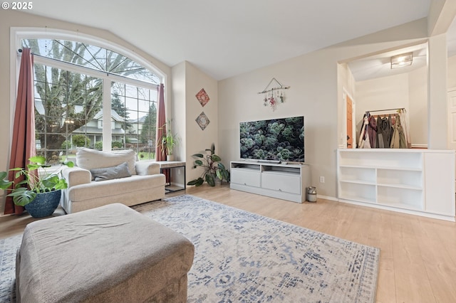 living room with a healthy amount of sunlight, wood-type flooring, and lofted ceiling