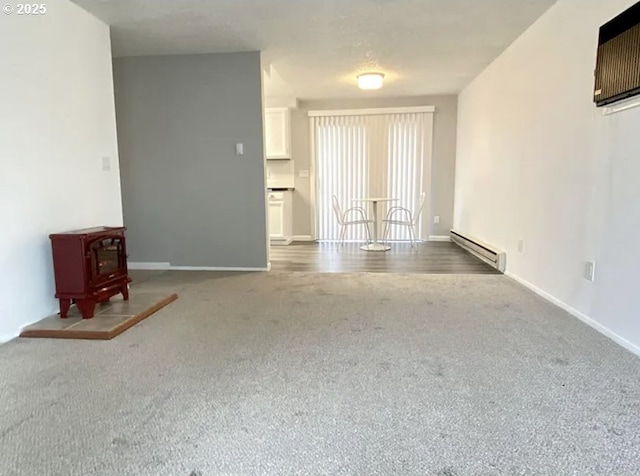 8416 SE Insley St, Portland, OR 97266 - unfurnished living room featuring baseboard heating, a wood stove, baseboards, and carpet flooring