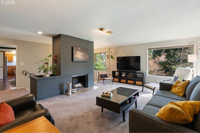 carpeted living area featuring a brick fireplace